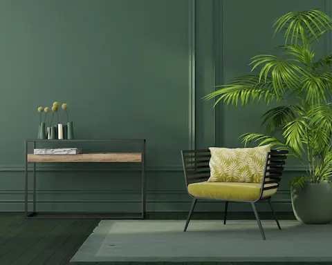 Dark green walls painted by Oregon City Painting, professional house painters, with modern decor and a stylish chair.